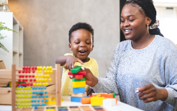 Woman playing blocks with young child 