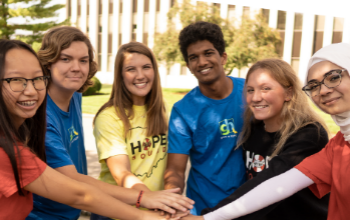 students with hands stacked in the middle wearing hope squad clothing